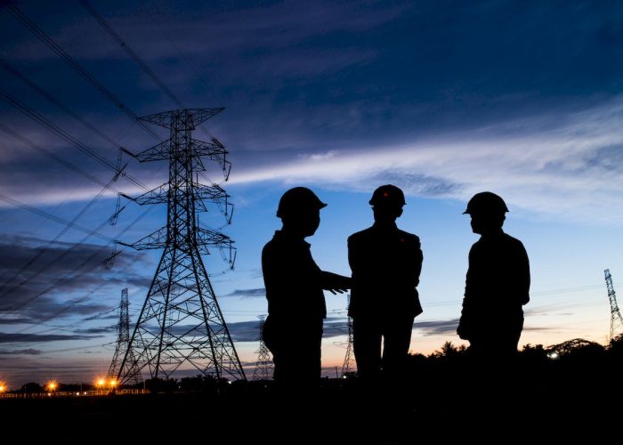 Silhouette,Man,Of,Engineers,Standing,At,Electricity,Station,Over,Blurred